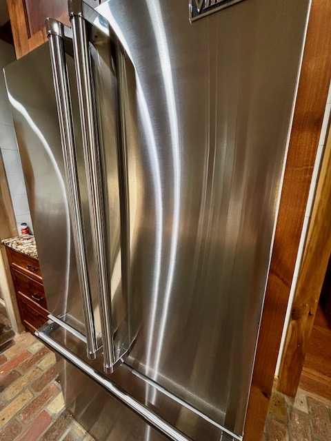 Freshly polished stainless-steel refrigerator in a clean kitchen
